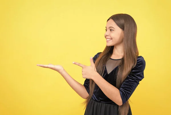 Kid make an advertisement. child advertising your product. happy childhood. time for shopping sales. look over there. presenting product. happy teen girl pointing finger on copy space. Online shop — Stock Photo, Image