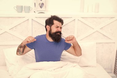 Sabah uykusu. Barışçıl yetişkin erkek dinleniyor. Sakallı adam yatakta geriniyor. Uykulu adam yatak odasında rahatla. Sabah erkenden. Vücudunun ihtiyacı olan dinlenme için. Yatak çok rahat.