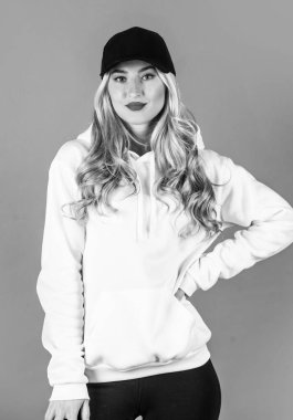 Sarı kıvırcık saçlı, şapkalı, kapüşonlu, şık bir kadın.