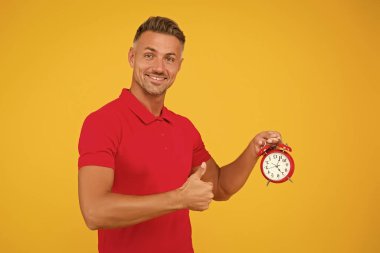 Doğruluk ve hassasiyet. Mutlu adam çalar saati tutar, parmaklarını kaldırır. Dakiklik ve doğru zaman tutma. Doğruluk sağlandı. Zaman standardı