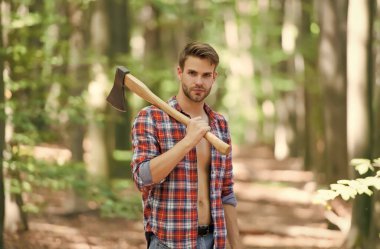 Yakışıklı adam ormanda baltayı tutuyor..