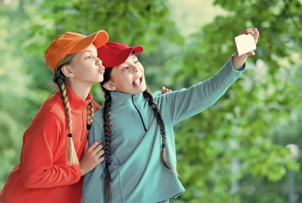 Echa un vistazo. Los niños graciosos se toman selfies juntos. Selfie tiro con teléfono inteligente. Dispositivo móvil. Tecnología moderna. Videollamada. Redes sociales. Casual en naturaleza — Foto de Stock