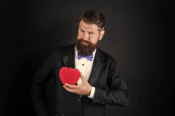 Homem barbudo em smoking formal com laço compartilhar coração amor no dia 14 de fevereiro dia dos namorados, amor — Fotografia de Stock