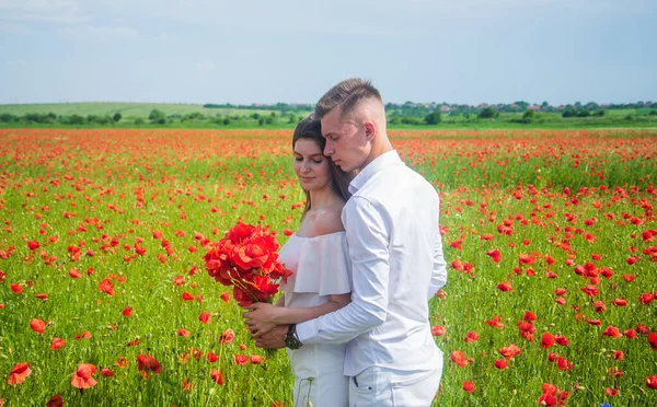 Пара закохана в чоловіка і жінку в літньому маковому квітковому полі, весілля — стокове фото