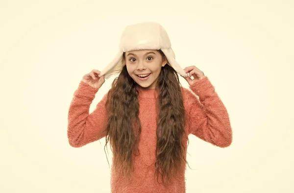 Tieni la testa nel cappello. Guarda il mio cappello con paraorecchie. felice ragazza in maglia maglione. maglieria e pelliccia per bambini. tendenze della moda invernale. bambino piccolo divertirsi isolato su bianco. preparazione vacanza — Foto Stock