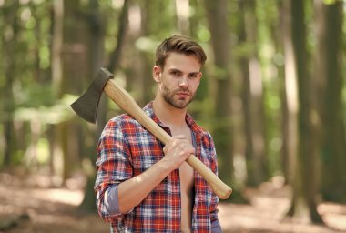 Vahşi doğaya doğru gidiyor. Yakışıklı adam vahşi doğada balta taşıyor. Oduncu tarzı. Yaz doğası. Doğa manzarası. Ekoloji ve çevre. Macera ve keşif. Ağaç kesme ve odun kesme