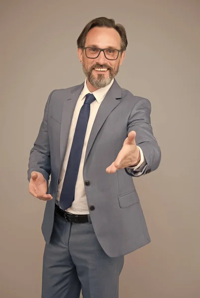 Natáhni ruku v uvítacím gestu. pohledný sebevědomý obchodník. Muž středního věku s brýlemi. Vypadáš chytře a inteligentně. muž s vousy a brýlemi je sebejistý. šťastně vypadající podnikatel — Stock fotografie