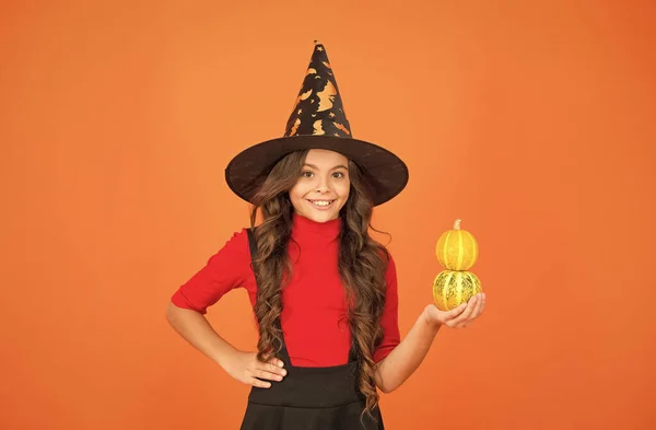 All you need is pumpkin. child celebrate autumn holiday. teenage girl in witch hat celebrate party. happy halloween. trick or treat. carnival festive costume of witch. kid with small pumpkin — Stock Photo, Image