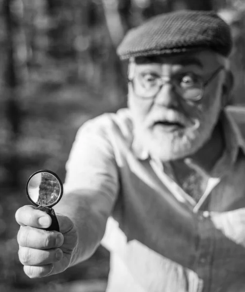 Sehen Sie klar. Lupe oder selektiver Fokus aus Glas. Objektiv und optisches Werkzeug. Ein alter Mann blickt durch eine runde Linse nach draußen. Handlinse. Die Natur untersuchen. Vergrößerung und Untersuchung. Naturbeobachtung — Stockfoto