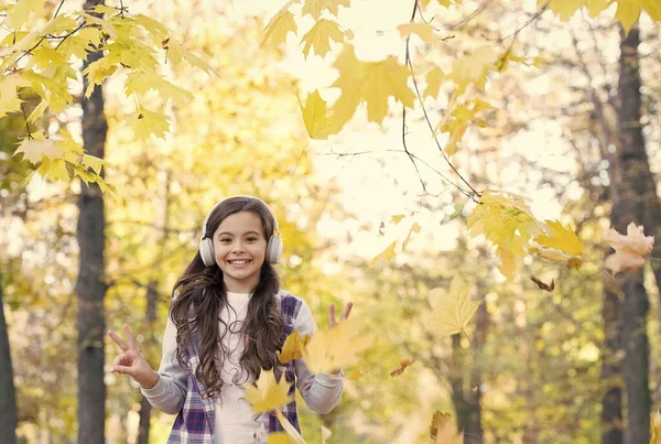 Moda autunno bambino. ispirazione. infanzia felice. Torniamo a scuola. ragazza con foglie nel parco. caduta bellezza nella foresta. godere della musica in cuffia. istruzione online e e-learning. Pronti per nuove avventure — Foto Stock