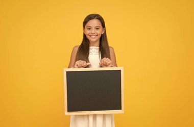 Oku şunu. Bilmen gereken bir şey var. Mutlu gülümseyen kız tahtayı tutuyor. Boş tahtası olan küçük bir çocuk. Reklam promosyon fotokopi alanı. Bilgi için tebeşir tahtası. Boş tahta