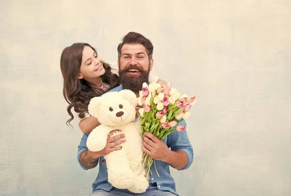 We love each other. teen girl and dad hold tulip bouquet. 8 march or womens day. spring holiday gift. love and family values. happiness. happy family day. father and daughter with flowers and toy — Stock Photo, Image