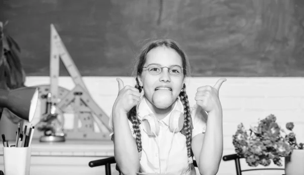 Conceito de vida escolar. Infância moderna. Intervalo escolar. Lanche entre as aulas. Estudante sentar mesa quadro fundo. Estudante na escola. Menina pequena criança comendo frutas de maçã. Estilo de vida saudável — Fotografia de Stock