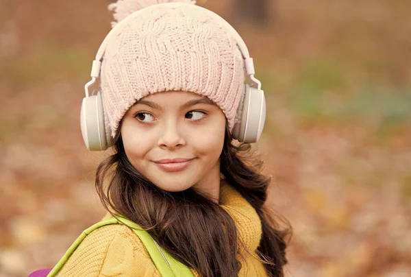 Kinder genießen Lieblingslieder. Lernen bringt Wissen. Mädchen mit Kopfhörer und Hut. Kinder hören Musik im Herbstpark. Herbst ist Studienzeit. Online-Schulbildung — Stockfoto