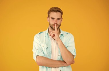 Sessiz jestli seksi adam sarı arka planda kot pantolon giyiyor, gizli.