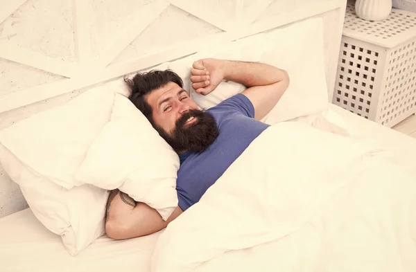 Foto pria tampan yang ceria bangun tidur tergeletak di dalam ruangan di depan kamera, rileks dan rekreasi — Stok Foto