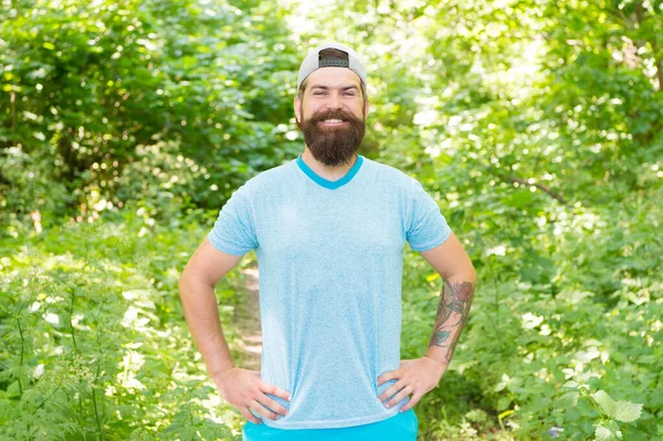 Mature bearded man with beard and moustache in summer shirt and cap in forest, active rest — Photo