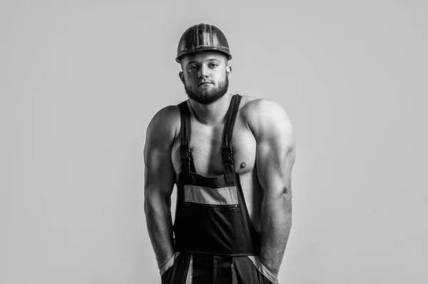 강한 몸을 가진 근육질의 건축가. 노동자 제복을 입고 있는 남자. 헬멧을 쓴 운동 선수. 몸 근육 이 있는 섹시 한 남자. 전문적 인 건설자 나 정비공. 건축 기사 — 스톡 사진