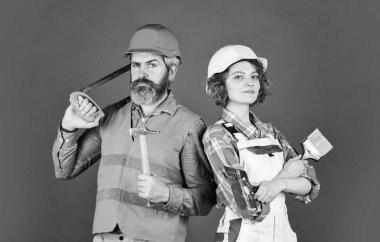 İyi kalite. Kendine güvenen tamircinin ve bayan meslektaşının portresi. Onarım adımlarını takip et. Özel üniforma giy ve aletleri kullan. Bakım servisi. bina konsepti. Yeni evlerini hayal et.