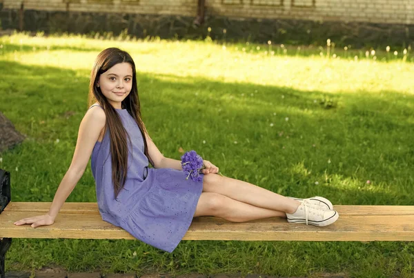 女孩的蓝裙子用新鲜的玉米花放松绿地，在公园里休息一下 — 图库照片