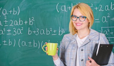 Çay fincanı ve yazı tahtası geçmişi olan bir kadın. Rahatlama zamanı. Rahatlamak ve pozitif kalmak için zaman ayır. Öğretmen çay ya da kahve iç ve pozitif kal. Olumlu düşünmeye devam et.