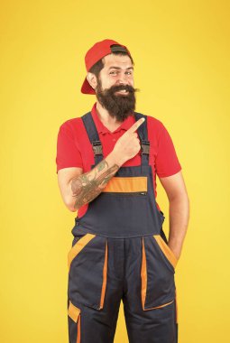 Mekanik servis üniformalı vahşi sakallı adam yetenekli tesisatçı ve yükleyici olarak çalışıyor.