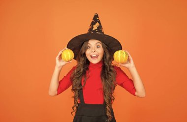 Kabak sebzesi. Cadı karnavalı kostümü. Küçük balkabaklı çocuk. Çocuk sonbahar tatilini kutluyor. Cadı şapkalı genç kız cadılar bayramını kutluyor. Cadılar bayramın kutlu olsun. Şaka mı şeker mi konsepti.