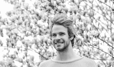 Baharın neşesi. Erkek çiçek arka planı. Bahar güzeli. Hippi çiçeğin tadını çıkarır. İlkbahar konsepti. Adam çiçek parkında rahatlıyor. Botanik bahçesi. Tazelik ve uyanış. Bahar ilham. Nisan Mayıs