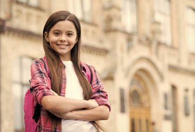 Uluslararası Çocuk Günü. Kendine güvenen çocuk okul bahçesinde kollarını kavuşturur. Okul eğitimi. 20 Kasım. Çocuklar Günü 'nde. Mutlu bir çocukluk. Parlak bir gelecek hayal etmek, boşluğu kopyalamak