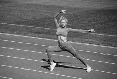 Sporcu ısınıyor. Dışarıdaki arenada ısın. Antrenman ve antrenman. Atletik bayan koç. Kadın spor eğitmeni. sağlıklı sportif yaşam tarzı. Sağlık ve enerji. Bayan spor kıyafetleri içinde geriniyor.