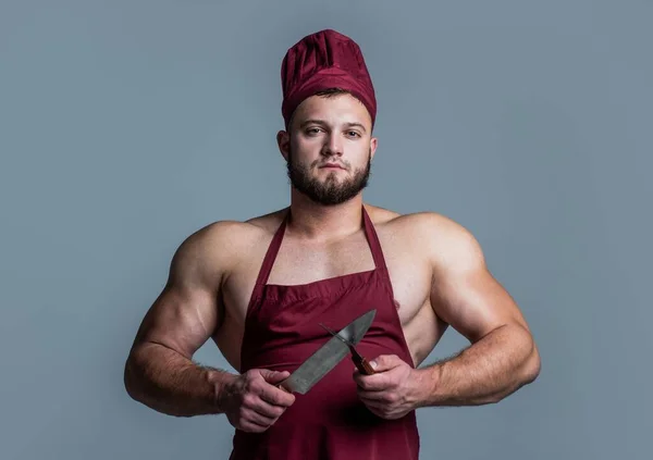 Мышечный мясник в фартуке шеф-повара держать нож посуда кухня, приготовление пищи — стоковое фото
