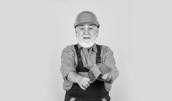 Después de terminar el trabajo. proceso de aplicación de la capa de masilla. Herramientas de enlucido para yeso. espátula de paleta de yeso en cartón yeso amarillo. Yesero en yeso uniforme de trabajo. hombre con espátula —  Fotos de Stock