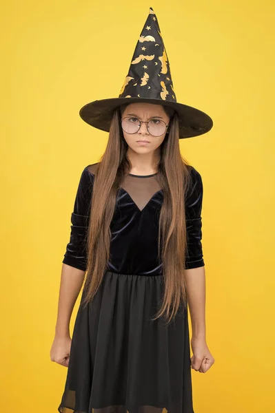 Kızgın ve mutsuz çocuk cadılar bayramında büyüye hazır cadı şapkası ve gözlüğü takar, mutlu cadılar bayramı — Stok fotoğraf