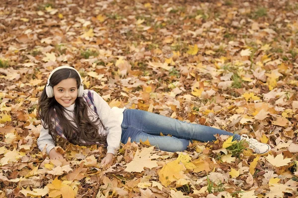 Glad tonåring flicka lyssna musik bär hörlurar i höstskogen med vacker säsongsbetonad natur eller ha online lektion, koppla av — Stockfoto