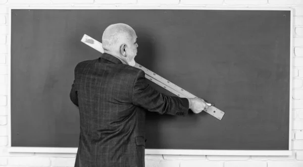 Starší muž učitel používat pravítko při kreslení. vousatý učitel kreslit s pravítkem na tabuli. Zpátky do školy. školní disciplíny. Vzdělání a znalosti. geometrické tvary na střední škole — Stock fotografie