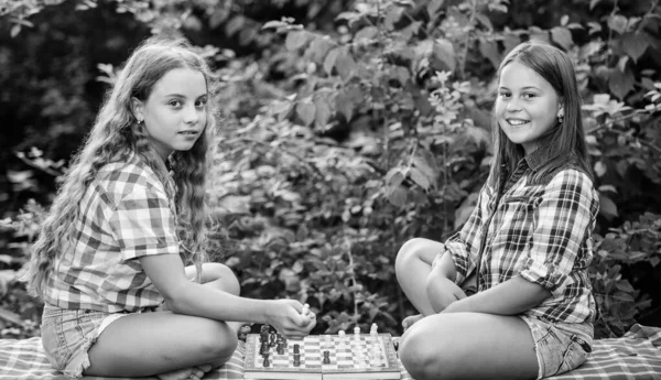 Desarrollo cognitivo. Juego intelectual. Toma una decisión. Niños inteligentes. Las niñas juegan al ajedrez. Hermanas jugando al ajedrez. Los niños juegan ajedrez al aire libre fondo de la naturaleza. Concepto de deporte y hobby — Foto de Stock