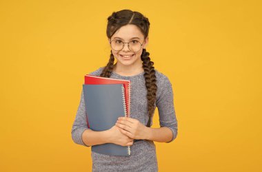 İçinde yaratıcılık uyandırmak için kitap oku. Mutlu çocuk kitapları tutuyor. Küçük sarı arka plan kitap kurdu. İlkokul kitapları. Edebiyat ve dil. Eğitim ve bilgi. Bu kitapları okuyabilirim.