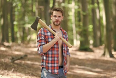 İçindeki oduncuyu serbest bırakıyorsun. Yakışıklı adam doğal manzarada balta taşıyor. Yaz tatili. Doğa yolculuğu. Doğal ortam. Ekoloji ve ekosistem. Ağaç kesme. Ormana yolculuk