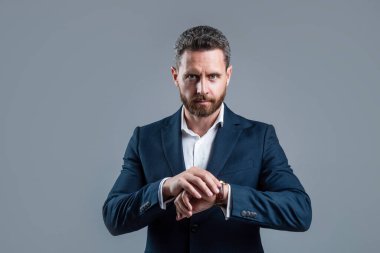 Takım elbiseli, sakallı adam kol saati, kontrol zamanı.