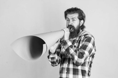 Şimdi işe alıyoruz. Kareli tişörtlü, kağıt megafonlu olgun bir adam. Havalı erkek hoparlör kullanıyor. Yüksek sesle konuş. Önemli bir duyurusu olan sakallı bir adam. Büyük açılış. pazarlama ve reklamcılık