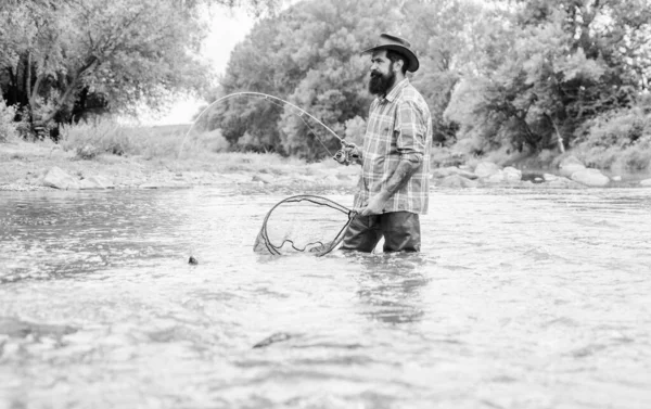 Summertime. hobby and sport activity. pothunter. mature man fly fishing. man catching fish. bearded fisher in water. fisherman with fishing rod. summer weekend. Big game fishing — Stock Photo, Image