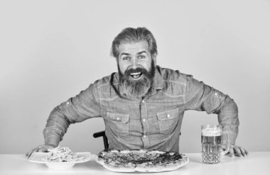 Bira ve yemek. Daha iyi olamazdı. Barda akşam yemeği. Aç adam pizza yiyecek ve bira içecek. Sonunda pizza zamanı. Pizzacı. Neşeli sakallı hippi adam pizza yiyor. Pizza partisi konsepti