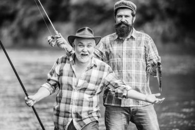 Nehirde güneşli bir yaz günü. Barışçıl balık avı. Baba oğul balık tutuyor. Büyükbaba ve olgun erkek arkadaşlar. Balıkçı ailesi. Rod müdahalesi. Balıkçılık malzemeleri. Hobi sporu. Dönen makarayla balık tutmak