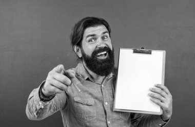 Sakallı ve bıyıklı yakışıklı adam not almak, kopyalamak, duyurmak için belge kağıdı gösteriyor.