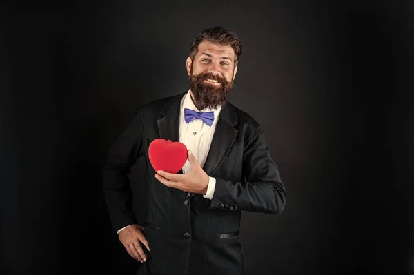 Feliz smoking homem com barba segurar romântico amor coração, feliz dia dos namorados — Fotografia de Stock