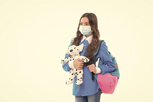 安全地返回学校。小孩戴着面具抱着玩具狗.个人卫生。环境卫生和个人卫生 — 图库照片