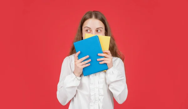 Dítě v bílé košili připraven ke studiu dělat domácí úkoly za knihy na červeném pozadí, znalosti — Stock fotografie