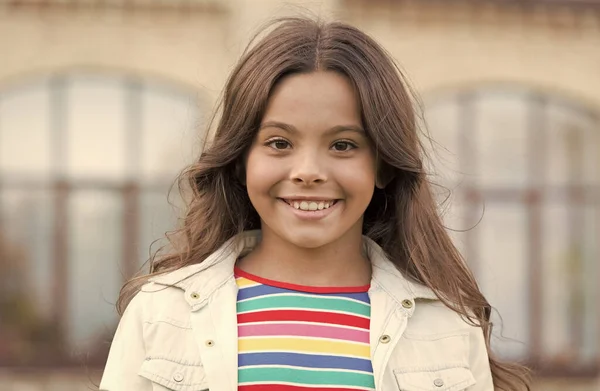 Menina pequena lindo penteado adorável sorriso fundo urbano, conceito de odontologia — Fotografia de Stock