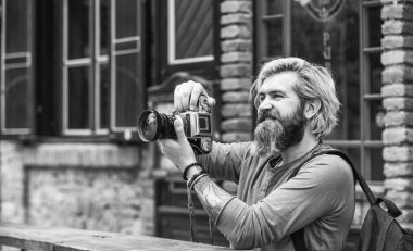 Modern iş. Gazeteci gazeteci. Retro kameralı acımasız bir adam. Eski teknoloji. Profesyonel fotoğrafçı klasik kamera kullanır. Fotoğrafçılık işi. Sakallı hippi adam fotoğraf çek.