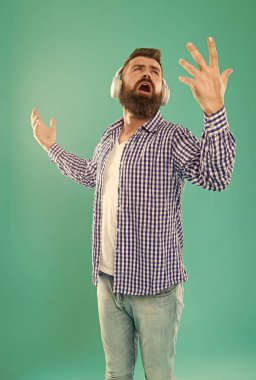 Sıradan tişörtlü sakallı adam şarkısını mavi arka plandaki yığınla şarkıyı dinle, müzik.